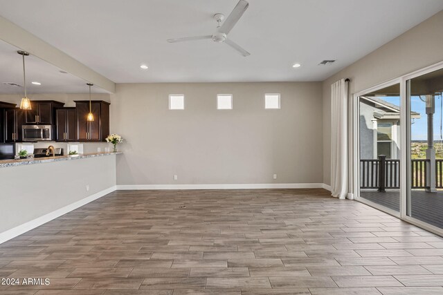 unfurnished living room featuring ceiling fan and light hardwood / wood-style flooring