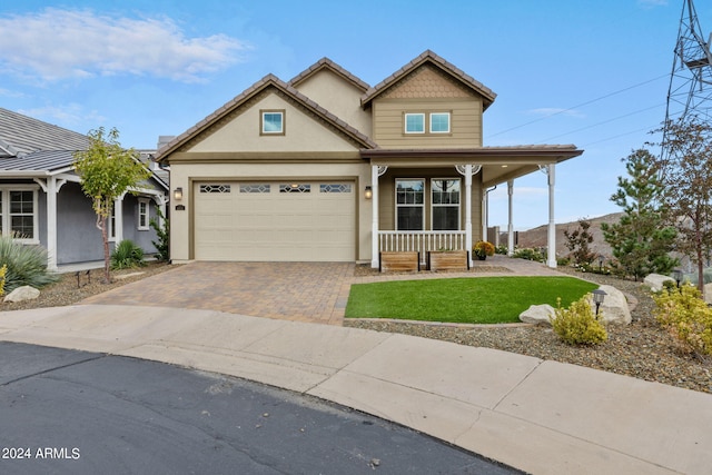 view of front facade featuring a front yard, a garage, and covered porch