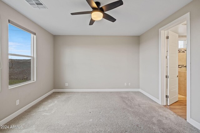 carpeted spare room featuring ceiling fan