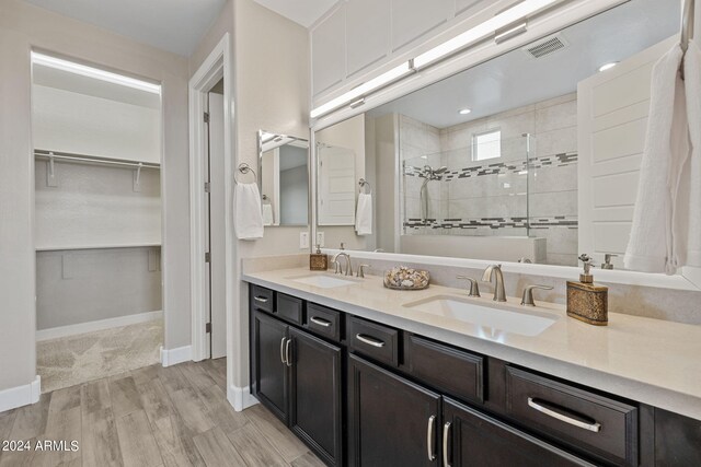 bathroom featuring a tile shower, vanity, and hardwood / wood-style floors