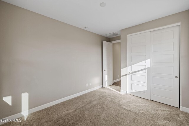 unfurnished bedroom with carpet floors and a closet