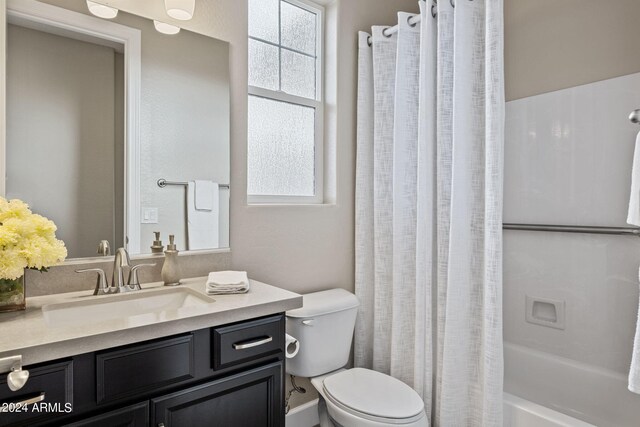 full bathroom with shower / bathtub combination with curtain, vanity, and toilet