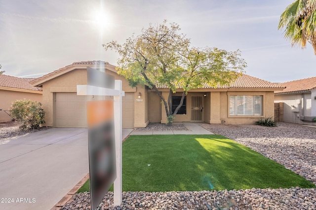 view of front of home with a garage and a front lawn