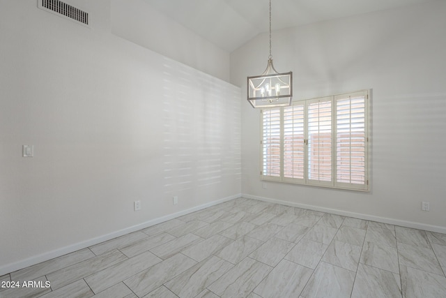 empty room with lofted ceiling and a chandelier