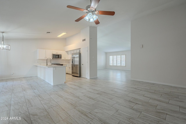 kitchen with ceiling fan with notable chandelier, high vaulted ceiling, white cabinets, kitchen peninsula, and stainless steel appliances