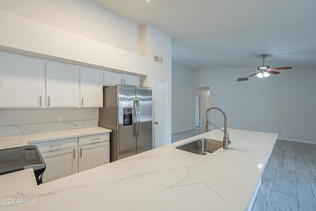 kitchen featuring sink, light stone countertops, stainless steel fridge with ice dispenser, and white cabinets