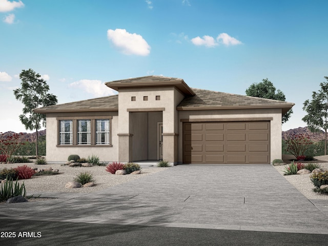 prairie-style home with stucco siding, an attached garage, and driveway