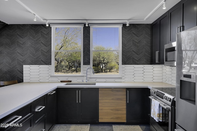 802 S 5th Ave, Tucson, AZ 85701 - kitchen with rail lighting, appliances with stainless steel finishes, wallpapered walls, dark cabinetry, and light countertops