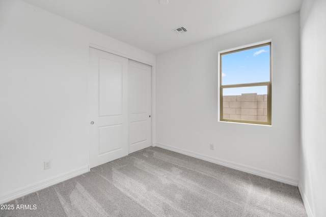 unfurnished bedroom featuring carpet and a closet