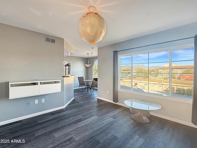 interior space with dark wood-style floors, baseboards, and visible vents