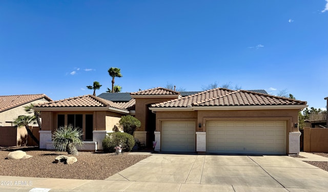 view of front of home with a garage, driveway, solar panels, a tile roof, and stucco siding