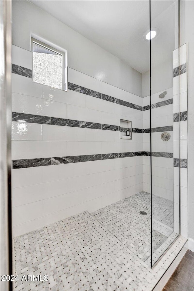 bathroom featuring tiled shower and hardwood / wood-style flooring