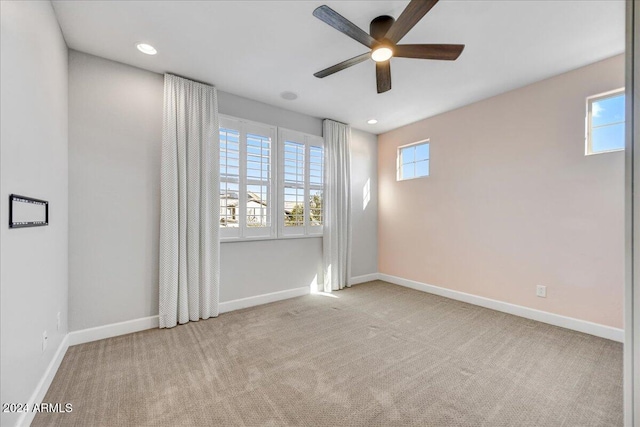 unfurnished room featuring ceiling fan and light colored carpet