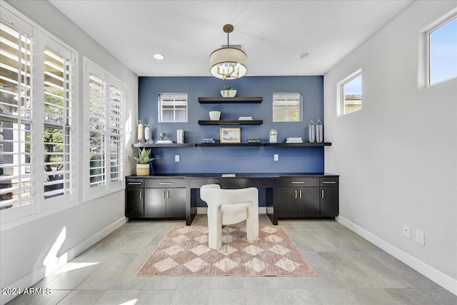 office area with a healthy amount of sunlight, built in desk, and light tile patterned floors