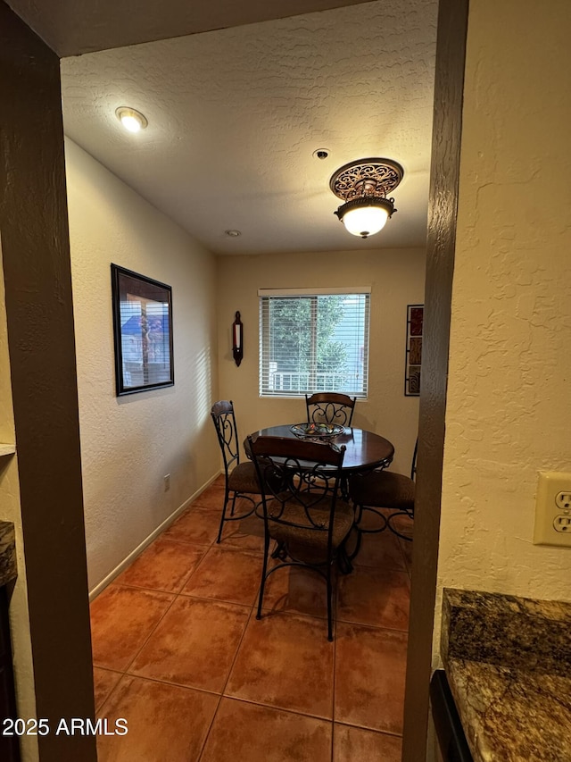 12123 W Bell Rd Unit 337, Surprise, AZ 85378 - dining area featuring tile patterned floors, a textured wall, a textured ceiling, and baseboards