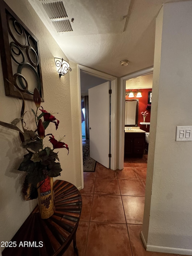 12123 W Bell Rd Unit 337, Surprise, AZ 85378 - hall with tile patterned flooring, baseboards, and a textured wall