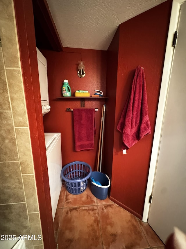 12123 W Bell Rd Unit 337, Surprise, AZ 85378 - bathroom featuring estacked washer and dryer, a textured ceiling, and tile patterned floors
