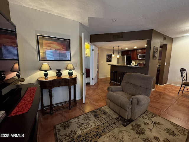 12123 W Bell Rd Unit 337, Surprise, AZ 85378 - tiled living room featuring a textured ceiling and baseboards