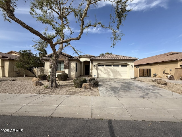 view of front of property featuring concrete driveway, an attached garage, a tile roof, and stucco siding