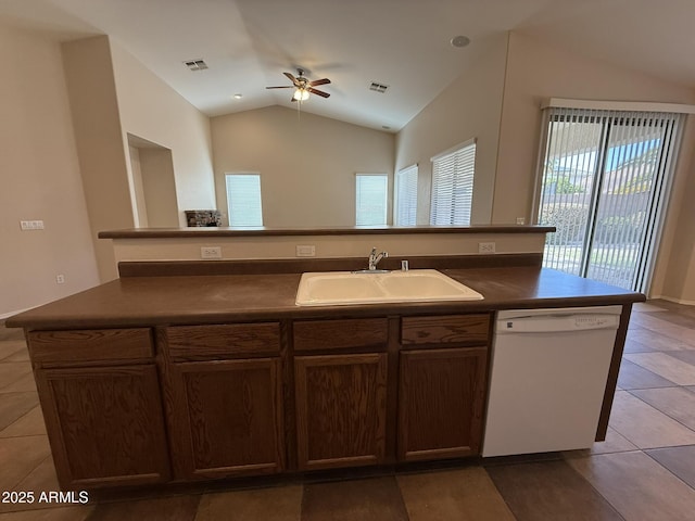 kitchen featuring dark countertops, white dishwasher, visible vents, and a sink