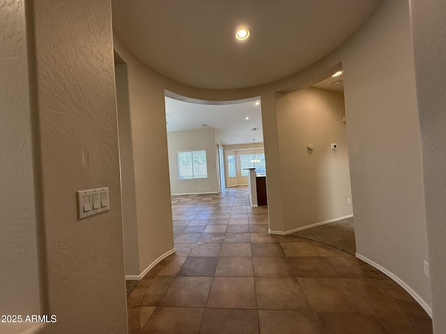 hallway with recessed lighting, baseboards, and tile patterned floors