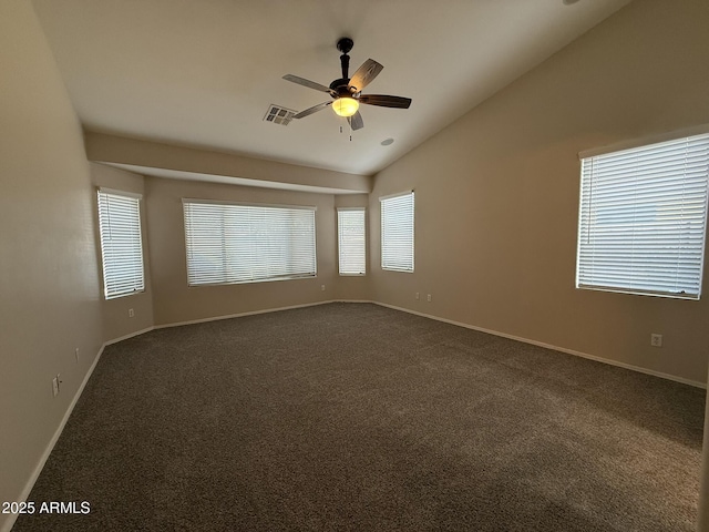 spare room with visible vents, baseboards, lofted ceiling, ceiling fan, and dark colored carpet