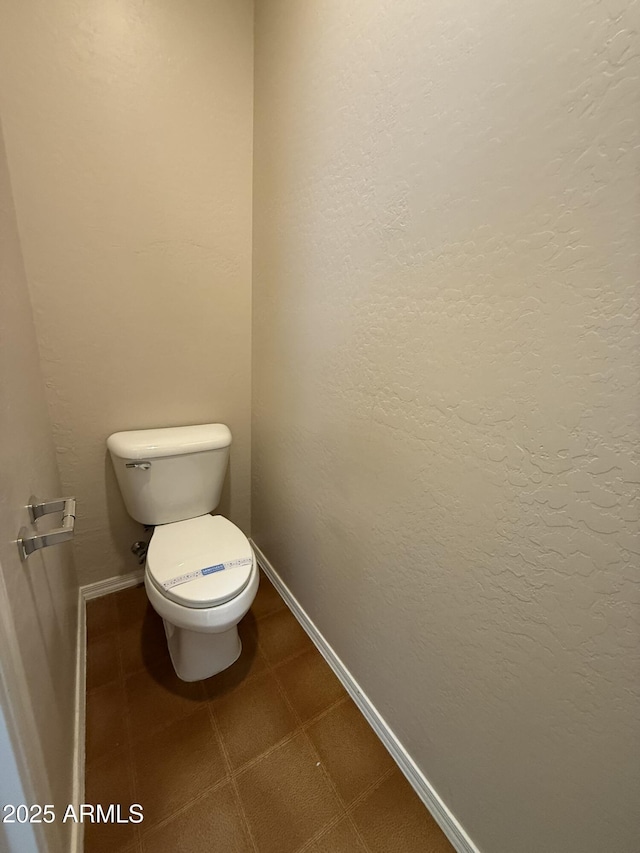 bathroom featuring toilet and baseboards