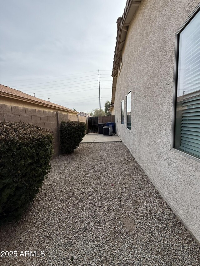 view of yard with a fenced backyard, central AC unit, and a patio