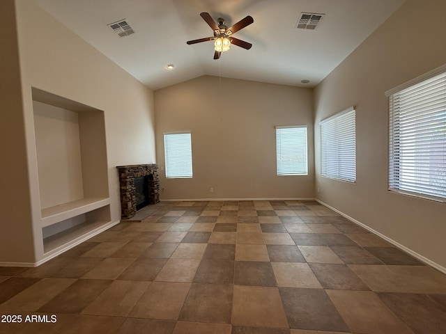 unfurnished living room featuring ceiling fan, a stone fireplace, visible vents, and baseboards