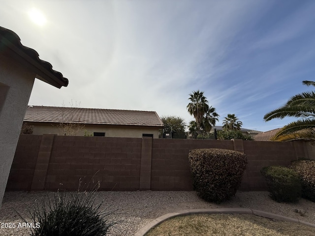 view of side of home with fence and stucco siding