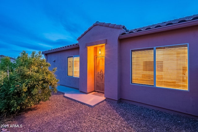 view of front of property with a tile roof and stucco siding