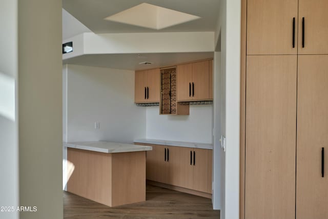 kitchen featuring hardwood / wood-style flooring and light brown cabinetry