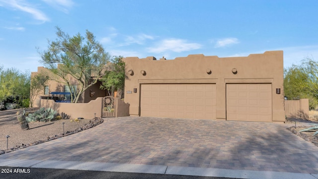 pueblo-style house featuring a garage