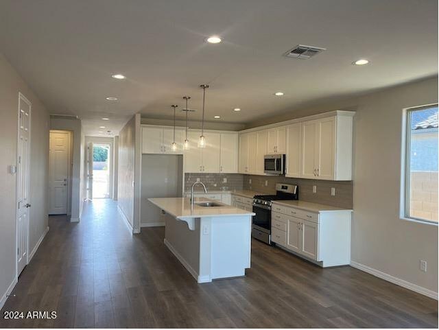 kitchen featuring white cabinetry, a kitchen island with sink, sink, and stainless steel appliances