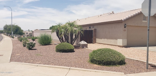 2004 N 108th Dr, Avondale, AZ 85392 - view of side of home with stucco siding, a garage, and concrete driveway