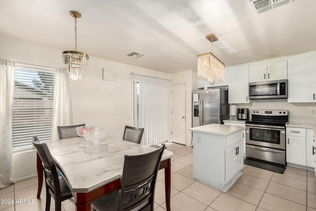 kitchen featuring a center island, an inviting chandelier, decorative light fixtures, and appliances with stainless steel finishes