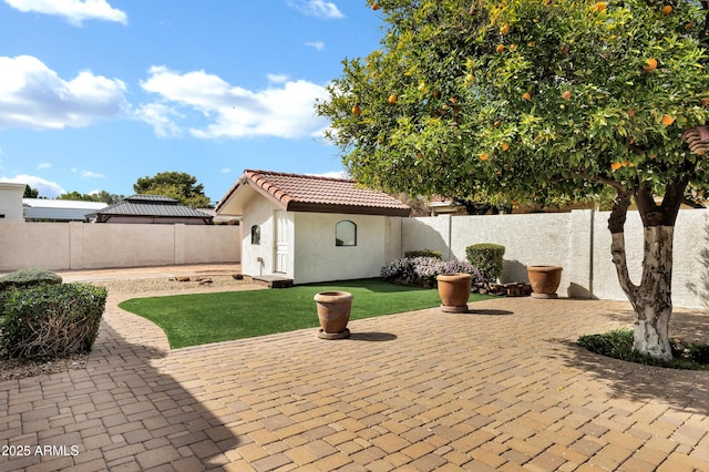 view of patio featuring an outdoor structure and a fenced backyard