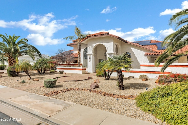 mediterranean / spanish home with stucco siding and a tiled roof