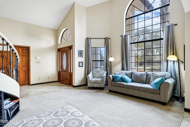 living room featuring stairs, baseboards, light colored carpet, and high vaulted ceiling