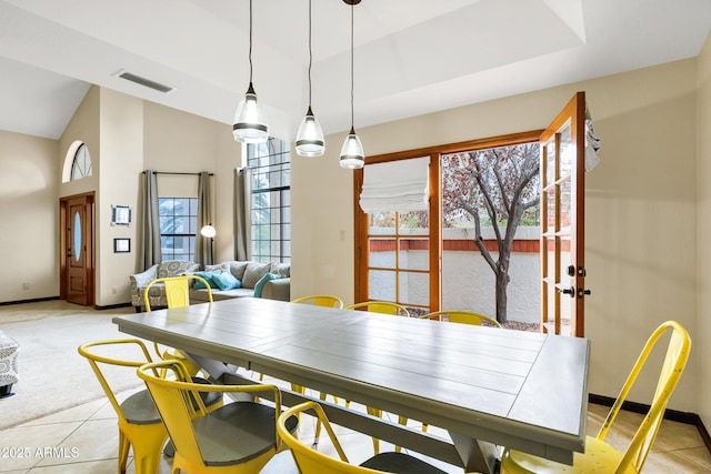 dining room with light tile patterned floors, visible vents, baseboards, and high vaulted ceiling