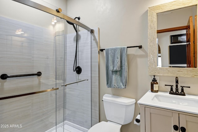 bathroom featuring vanity, toilet, and a stall shower