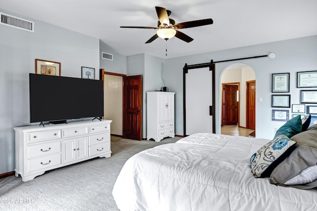 bedroom featuring light colored carpet, arched walkways, visible vents, and baseboards