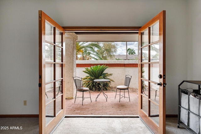 doorway featuring carpet flooring, french doors, baseboards, and brick floor