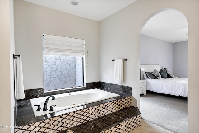 full bathroom with tile patterned floors and a tub with jets