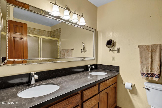 bathroom featuring a sink, toilet, double vanity, and a shower stall