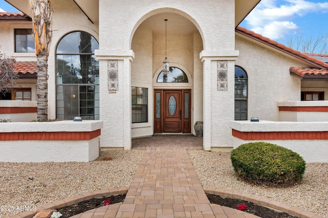 property entrance featuring stucco siding and a tile roof