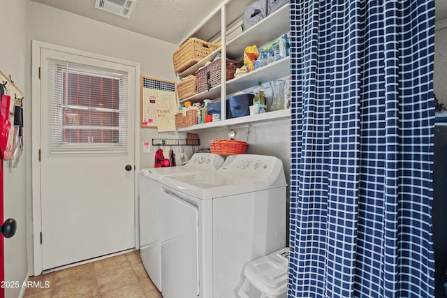 washroom featuring a textured ceiling and washing machine and clothes dryer