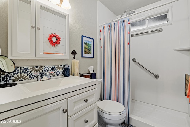 bathroom with vanity, backsplash, toilet, and curtained shower