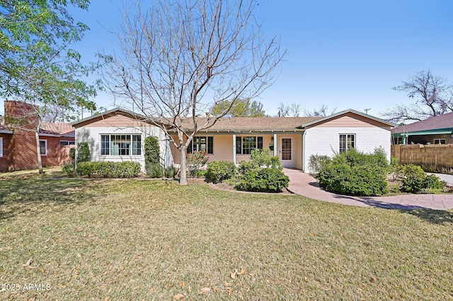 single story home featuring a front lawn, fence, and brick siding