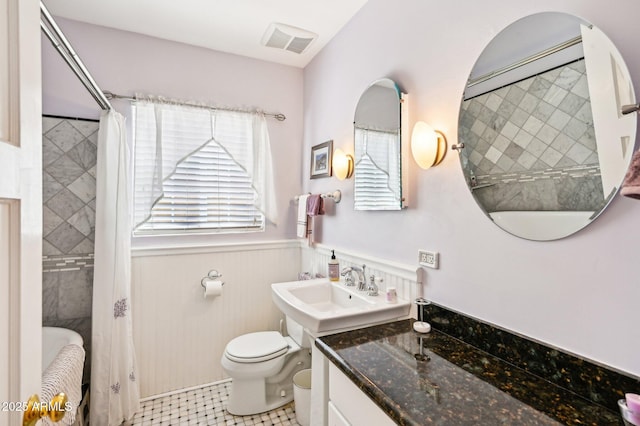 full bath featuring toilet, visible vents, a shower with shower curtain, and wainscoting